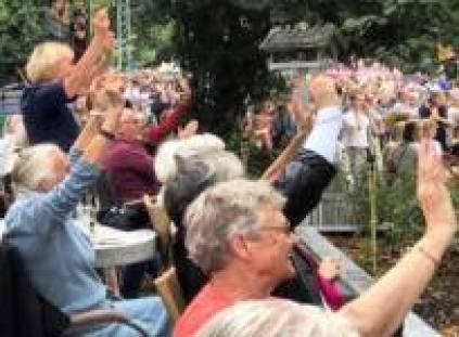 Mennesker på OK-krams terrasse vinker ad Copenhagen Pride